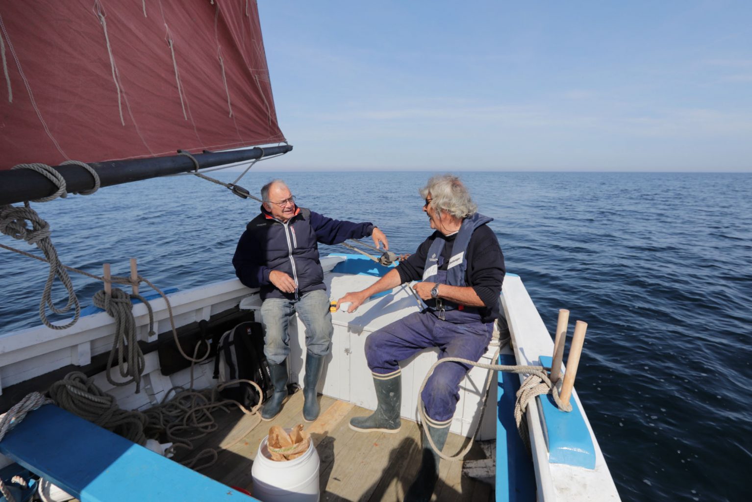 Équipage à bord de Barr Awel sous ses voiles rouges