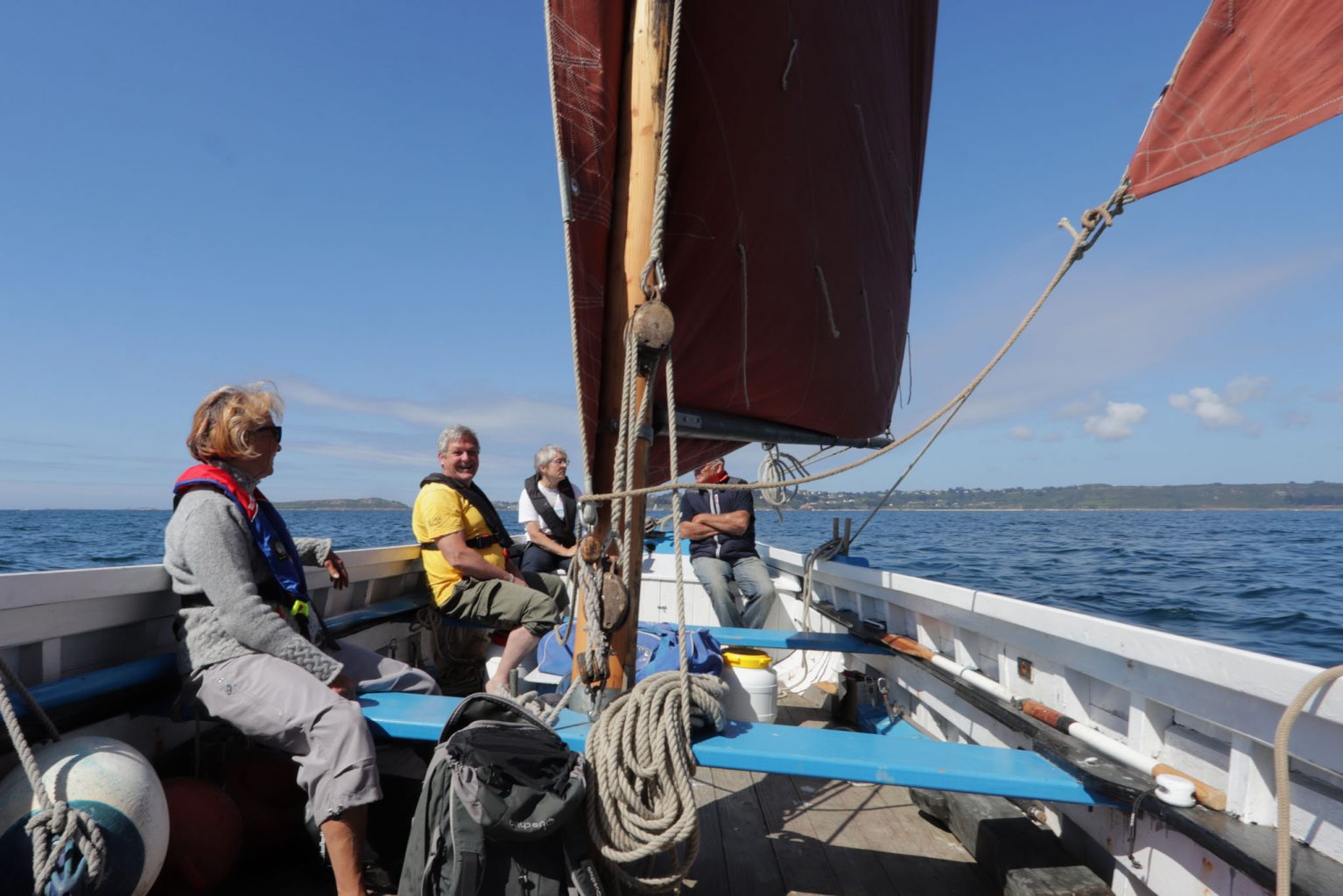 Équipage naviguant sur Barr Awel sous ses voiles rouges